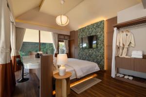a bedroom with a bed and a sink and a mirror at J Valley Resort in Pong Yaeng