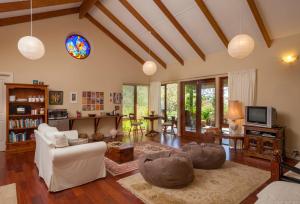 a living room with a couch and a tv at Innisfree Mountain Retreat in Denmark