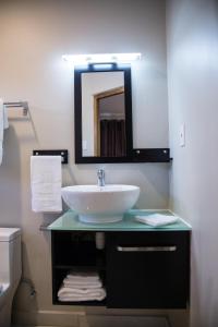 a bathroom with a sink and a mirror at The Pier Beach Inn & Suites in Willemstad