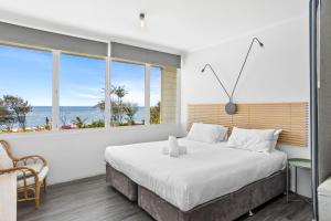 a bedroom with a large bed with a view of the ocean at Rosslyn Bay Resort Yeppoon in Yeppoon +41 photos