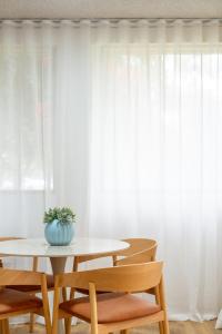 a table and chairs in front of a white curtain at Park side on East Terrace in Adelaide
