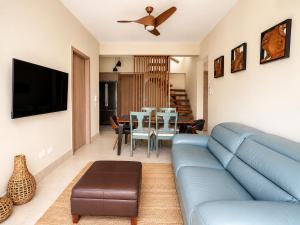 a living room with a blue couch and a table at Luxurious Ocean View Penthouse in Boca Chica