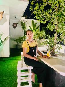a woman is sitting at a table in a garden at Mango Tree House Yala Safari Hotel in Tissamaharama +129 photos
