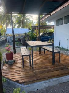 a picnic table and two benches on a wooden deck at Le KAHAIA Rangiroa Tiputa in Rangiroa