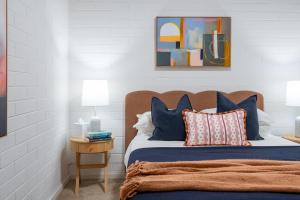 a bedroom with a bed with blue and orange pillows at Park side on East Terrace in Adelaide