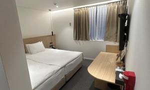 a small room with a bed and a table at Pohang Daejamdong Route 422 in Pohang