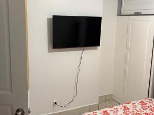 a flat screen tv hanging on a white wall at Grapes of Grace3 in Baie Nettle