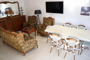 a living room with chairs and a table and a tv at Grapes of Grace3 in Baie Nettle