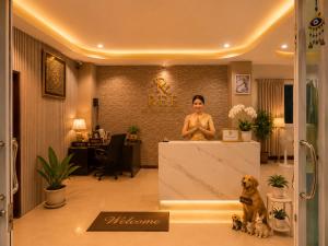 a woman in a room with a dog sitting at a counter at Ree- Riverside hotel in Bangkok