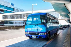 a blue and white bus parked in a parking lot at HOTEL MYSTAYS Haneda in Tokyo