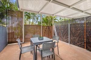 a table and chairs on a patio with a fence at Rosslyn Bay Resort Yeppoon in Yeppoon