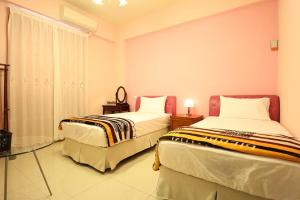 - une chambre avec 2 lits et une table en verre dans l'établissement Marathon B&B, à Taïtung