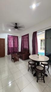 a living room with a table and a couch at Ayem Resort Langkawi in Air Hangat