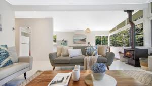 a living room with a couch and a fireplace at Pool, Pet - Friendly, Fireplace, Walk To Beach in Pearl Beach