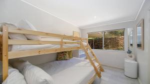 a bedroom with two bunk beds and a window at Pool, Pet - Friendly, Fireplace, Walk To Beach in Pearl Beach +9 photos