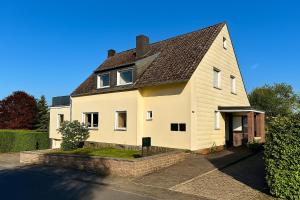 ein weißes Haus mit braunem Dach in der Unterkunft Eifelpause Vulkan in Bleckhausen