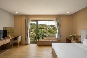 a bedroom with a bed and a large window at Gold View Boutique Hotel Đà Lạt in Da Lat