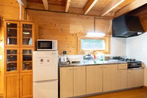 a kitchen with a refrigerator and a microwave at S-villa Nasu 12th in Nasu-yumoto
