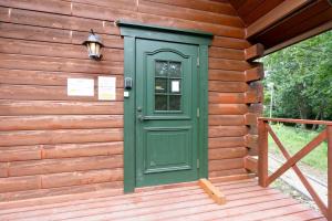 a green door on the side of a log cabin at S-villa Nasu 12th in Nasu-yumoto