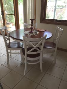 uma mesa de jantar com 4 cadeiras, uma mesa e uma vela em Clarevale Cottage B&B em Clare