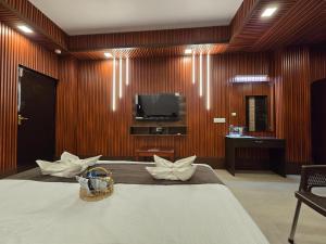 a hotel room with a bed and a television at Hotel The King's in Port Blair