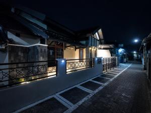 an empty street at night with lights on a fence at Abadi Homestay Yogyakarta in Yogyakarta