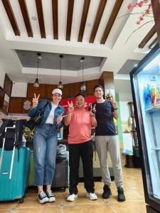 three people standing in a room with their hands up at A deer has you INN near by Tianmen Shan--Free pick-up-Aerial Cableway in Zhangjiajie
