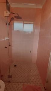 a bathroom with a shower with pink tile at Le Maroc at Bar Beach in Newcastle
