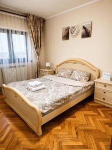 a bedroom with a bed with two towels on it at COZY PANORAMA Flat in Alba Iulia +4 photos