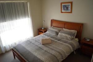 a bedroom with a bed with a pillow on it at Tooleybuc River Retreat Villas in Tooleybuc