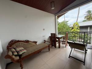 a living room with a couch and a table on a balcony at Tanzanite place in Tangalle