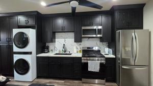 a kitchen with black cabinets and stainless steel appliances at Cozy Tiny Home For 2 People Studio Type in Norwalk