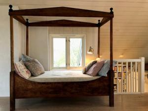 a canopy bed in a bedroom with a window at Architect-Designed House With Pier In Ny Hellesund in Søgne