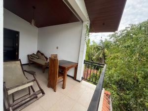 a patio with a table and a couch on a porch at Tanzanite place in Tangalle