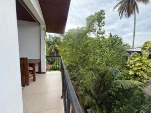 a balcony of a house with a table and trees at Tanzanite place in Tangalle
