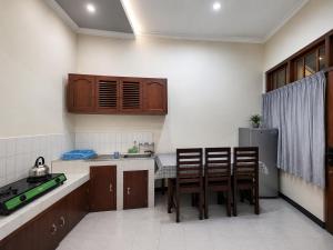 a kitchen with wooden cabinets and a table and chairs at Abadi Homestay Yogyakarta in Yogyakarta