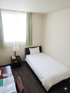 a hotel room with a bed and a window at ビジネスホテル圭 in Kimiidera