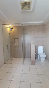 a bathroom with a toilet and a glass shower at Morgah Resort - Guest Rooms in Rawalpindi +7 photos