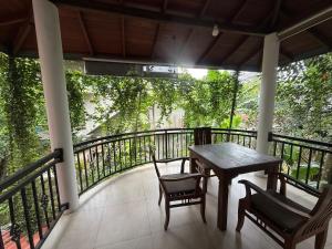 a porch with a table and chairs on a balcony at Tanzanite place in Tangalle
