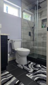 a bathroom with a toilet and a glass shower at Cozy Tiny Home For 2 People Studio Type in Norwalk +3 photos