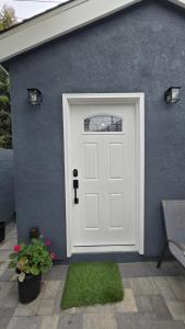 a white garage door with a window on a blue wall at Cozy Tiny Home For 2 People Studio Type in Norwalk