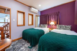 two beds in a room with purple and green at S-villa那須Audrey in Nasu
