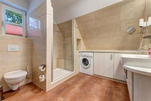 a bathroom with a toilet sink and a washing machine at Küstenhaus Koserow in Koserow