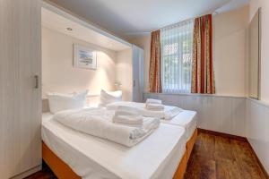 a large white bed in a room with a window at Küstenhaus Koserow in Koserow