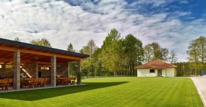 a lawn with a pavilion and a house at Lipowa Przystań in Tarnów Jezierny