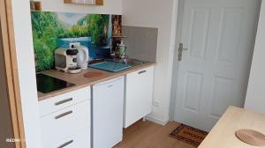 a kitchen with white cabinets and a counter top at le Cocon du Causse in Causse-de-la-Selle