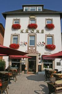 um hotel com mesas e cadeiras em frente em Hotel Krone Rüdesheim em Rüdesheim am Rhein