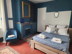 a blue bedroom with a bed and a chair at Marie-Claire la grillade in Briare