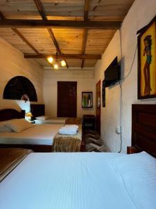 a hotel room with two beds and a tv at Casa de La Abuela Irene in Calarcá