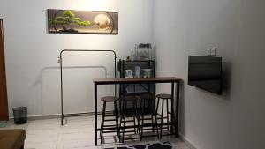 a kitchen with a table and stools in a room at Rembulan Guesthouse in Mersing